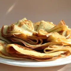 Stosik pysznych, domowych naleśników po polsku, lekko zarumienionych na brzegach, czeka na talerzu.