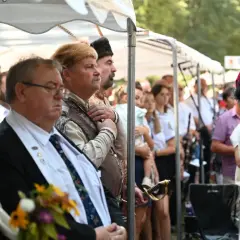 Uroczystość z udziałem mężczyzn w historycznych strojach, jeden z nich ma szablę. Czy to jakaś **maledizione po polsku**?