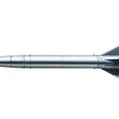 Srebrzysta rakieta, czyli missile po polsku, z ostrym stożkiem i trójkątnymi stabilizatorami, gotowa do startu.
