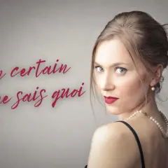 Kobieta w perłach i czerwonej szmince, z francuskim napisem "un certain je ne sais quoi".