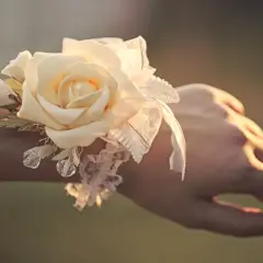 Delikatny corsage po polsku z kremową różą, koronką i kryształkami na nadgarstku.