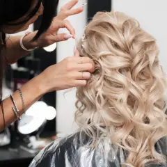 Fryzjer po hiszpańsku, czyli "peluquero", tworzy piękną fryzurę ślubną z blond loków.