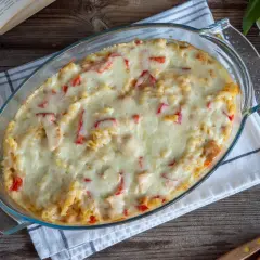 Zapiekany makaron z kurczakiem i papryką, polany kremowym sosem serowym. Pyszny makaron po francusku, gotowy do podania.