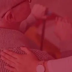 Pracownik socjalny wspiera seniora w domu opieki lub podczas wizyty domowej, oferując pomoc i troskę.