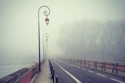 Most na moście w gęstej mgle, po francusku "brouillard". Latarnie tworzą tajemniczy nastrój.