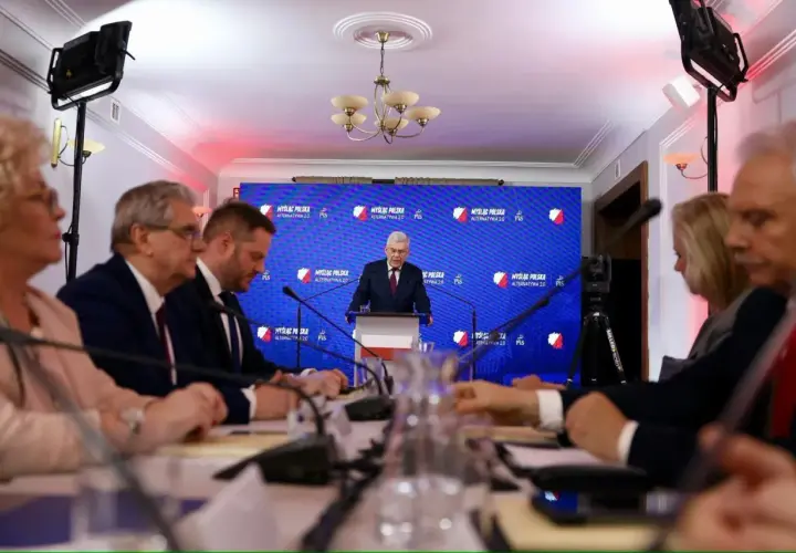 Ludzie siedzą przy stole, słuchając przemówienia. To pokazuje, co można robić po prawie – brać udział w debatach i konferencjach.