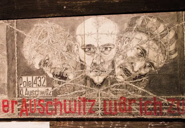 Rysunek trzech twarzy spętanych drutem kolczastym. Napis "KL Auschwitz" i czerwone litery "er Auschwitz war ich". To nie są tylko słowa, to historia.