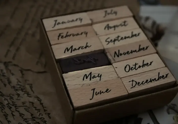 Drewniane stemple z nazwami miesięcy. Widać stempel z napisem "June" (czerwiec), obok "May" (maj) i "July" (lipiec).