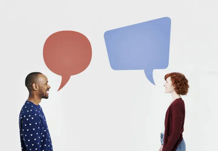 Mężczyzna i kobieta rozmawiają, nad nimi dymki dialogowe.