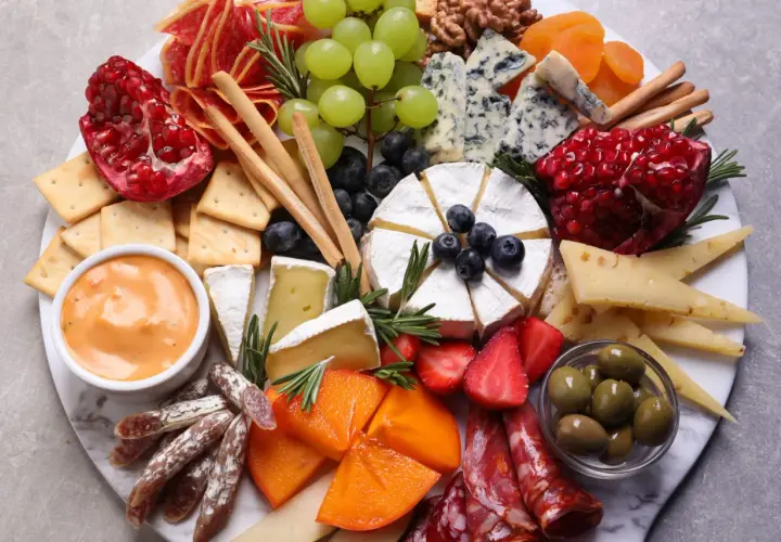 Wykwintna deska serów i wędlin, czyli polskie charcuterie: sery pleśniowe, camembert, owoce, oliwki, krakersy i dip.
