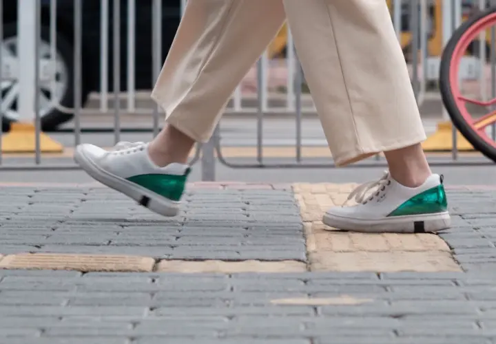 Białe sneakersy z zielonym akcentem na pięcie, idealne na spacer. Zastanawiasz się, jaki rozmiar buta francuski a polski wybrać?