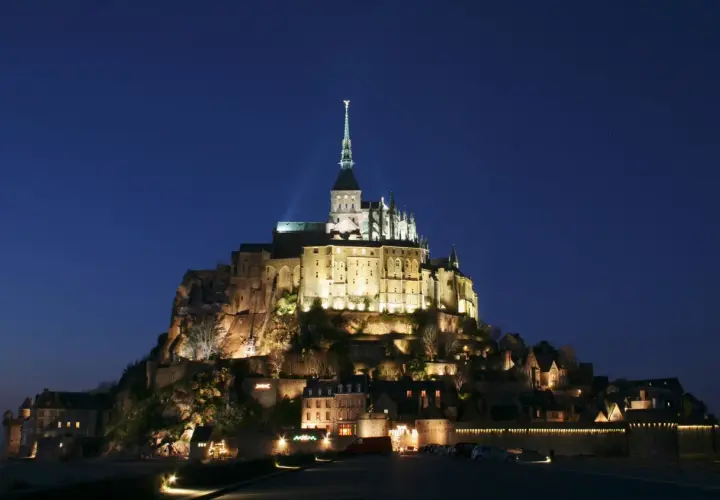 Mont Saint-Michel nocą, jakby z francuskiej baśni. Michał po francusku, czyli Mont Saint-Michel, lśni w ciemnościach.