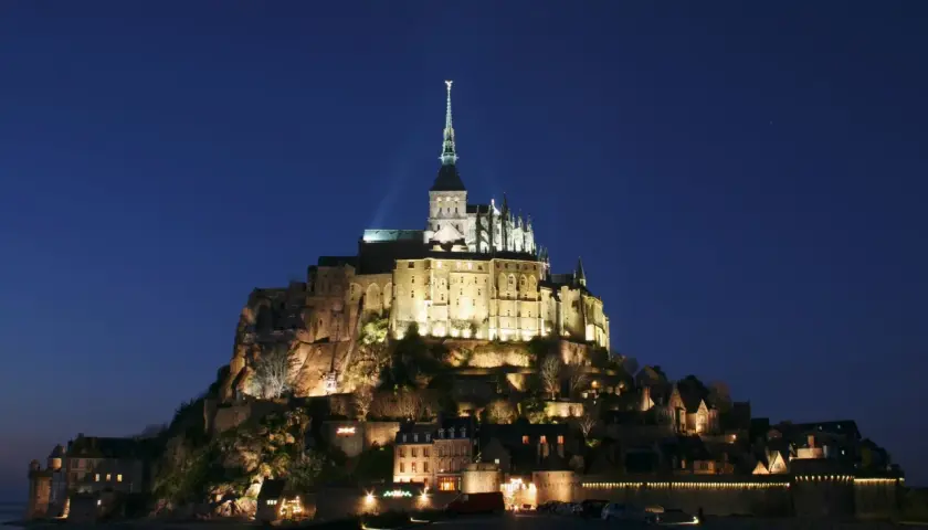 Mont Saint-Michel nocą, jakby z francuskiej baśni. Michał po francusku, czyli Mont Saint-Michel, lśni w ciemnościach.