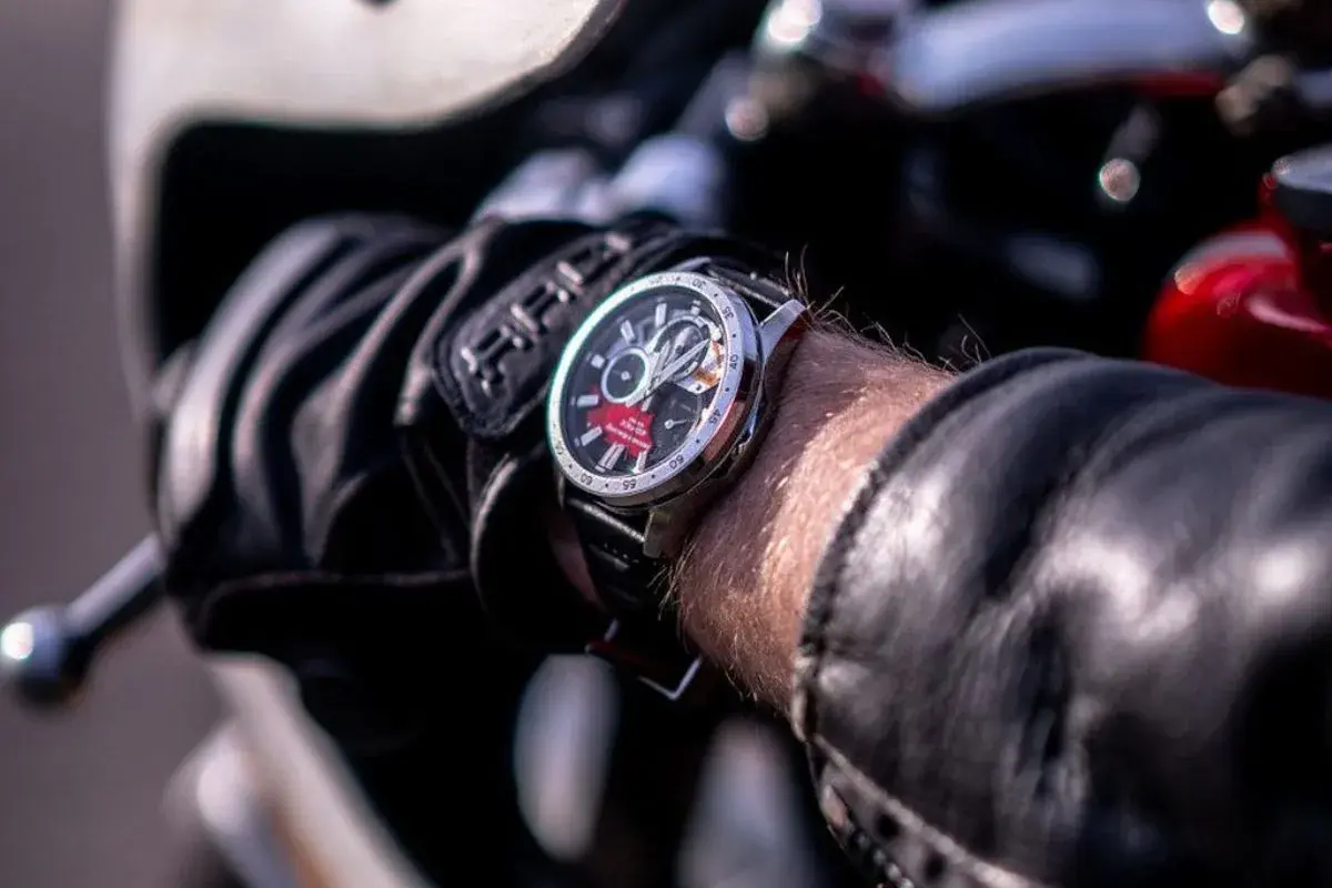 Mężczyzna w skórzanej kurtce i rękawicach motocyklowych sprawdza czas na zegarku Edifice. Czerwony akcent na tarczy dodaje mu charakteru.
