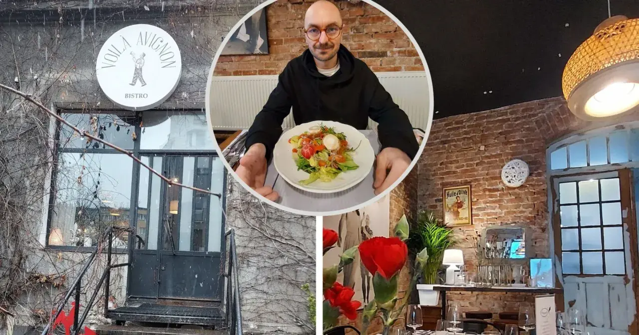 Voila, co znaczy to bistro! Mężczyzna z okularami prezentuje sałatkę w przytulnym wnętrzu z ceglanymi ścianami i stylowymi lampami.