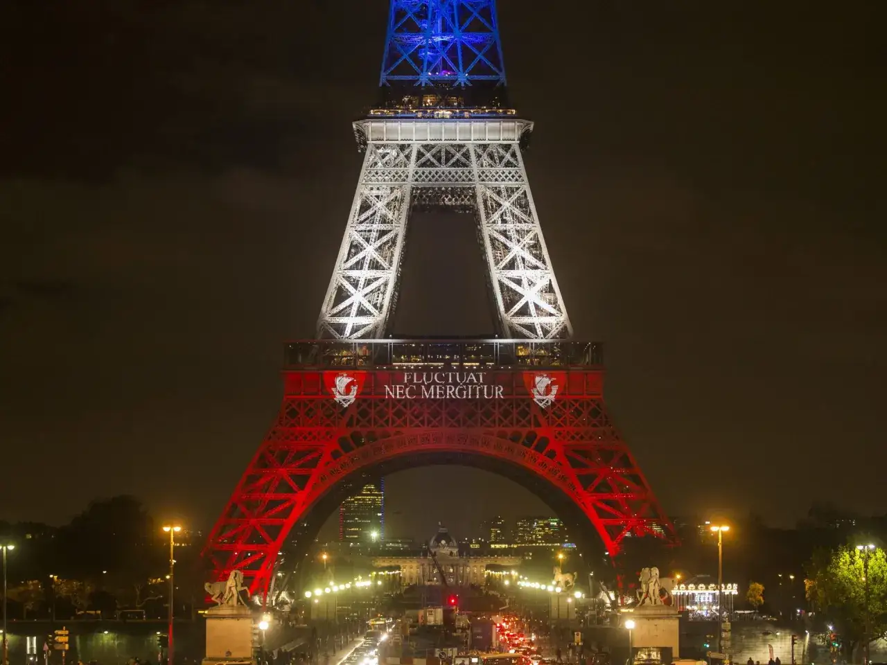 Wieża Eiffla w nocnych barwach Francji, z napisem