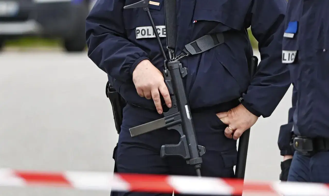 Francuska policja w pełnym rynsztunku, jeden z funkcjonariuszy trzyma broń.